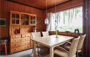 Ejstrup的住宿－Cozy Home In Ejstrupholm With Kitchen，一间带木桌和椅子的用餐室
