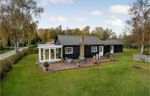 una casa en blanco y negro con un patio en Nice Home In Juelsminde With Kitchen en Juelsminde