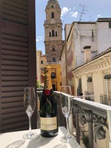 マラガにあるHolidays2Malaga Cathedral Viewのワイングラス2杯付きのテーブルに座ったワイン1本