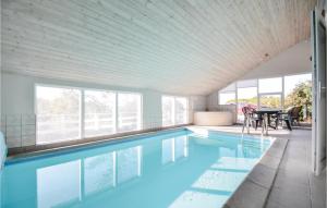 una piscina en una casa con mesa y sillas en Nice Home In Knebel With Indoor Swimming Pool en Skødshoved Strand