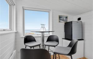 a dining room with a table and chairs and a window at Gorgeous Home In Allinge With Sauna in Allinge