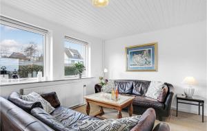a living room with two leather couches and a table at Gorgeous Home In Allinge With Sauna in Allinge
