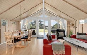a living room with a red couch and a table at Amazing Home In Skjern With Kitchen in Halby