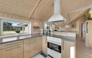 a kitchen with wooden cabinets and a stove top oven at Amazing Home In Skjern With Kitchen in Halby