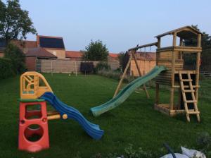 ein Spielplatz mit Rutsche und einem Spielgerät aus Holz in der Unterkunft Kunstmin in Zandvoorde