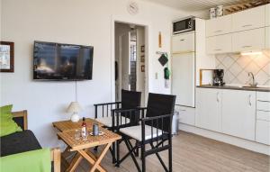 a living room with a table and chairs and a kitchen at Apartment Vejers Sydstrand I-937 in Vejers Strand +6 photos