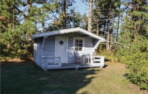 ein kleiner weißer Schuppen im Gras in der Unterkunft Four-Bedroom Holiday Home In Sjallands Odde in Yderby + 11 Fotos
