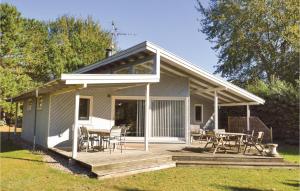 ein Haus mit einer Terrasse mit Tischen und Stühlen in der Unterkunft Four-Bedroom Holiday Home In Sjallands Odde in Yderby