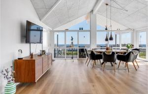 a dining room with a table and chairs and a television at Beautiful Home In Hejls With Wifi in Hejls