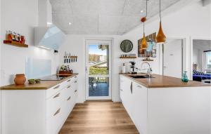 a kitchen with white cabinets and a wooden floor at Beautiful Home In Hejls With Wifi in Hejls