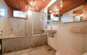 ein Badezimmer mit Badewanne, Waschbecken und Toilette in der Unterkunft Four-Bedroom Holiday Home In Sjallands Odde in Yderby