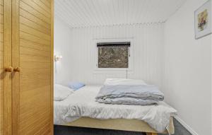 エーベルトフトにあるBeautiful Home In Ebeltoft With 3 Bedrooms And Wifiのベッドと窓が備わる小さな白い客室です。