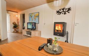 a living room with a table and a tv at Stunning Home In Sydals With Kitchen in Vollerup
