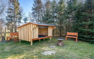 a wooden shed and two benches in a yard at Beautiful Home In Storvorde With Sauna in Storvorde +10 photos
