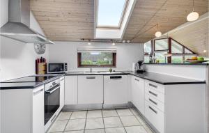 a kitchen with white cabinets and black counter tops at Holiday Home Kaninstien Vi in Marielyst