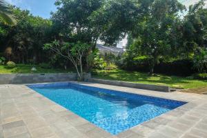 a swimming pool in a yard next to a garden at SAREH VILLA by The Lavana in Semarang