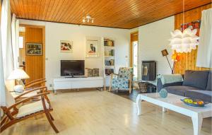 ein Wohnzimmer mit Sofa und Fernseher in der Unterkunft Awesome Home In Aakirkeby With Kitchen in Vester Sømarken