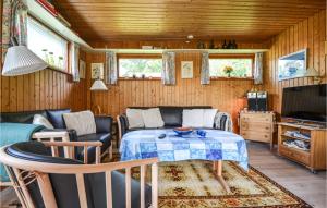 a living room with a table and a couch at Cozy Home In Glesborg With Kitchen in Fjellerup Strand