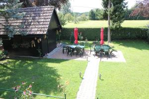 un patio avec des tables, des chaises et des parasols rouges dans l'établissement Rooms4Young, à Ljubljana