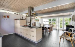 cocina con armarios blancos y comedor en Cozy Home In Ebeltoft With Kitchen, en Ebeltoft