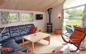 sala de estar con sofá y estufa de leña en Beautiful Home In Sklskr With 4 Bedrooms, Sauna And Wifi, en Skælskør
