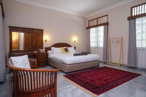 a bedroom with a bed and a desk and a chair at SAREH VILLA by The Lavana in Semarang