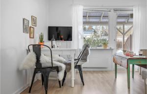 sala de estar con mesa, sillas y TV en Gorgeous Apartment In Nex With Kitchen, en Neksø