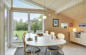 a kitchen and dining room with a white table and chairs at Holiday Home Soløjevej in Marielyst
