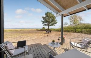 a deck with chairs and a table on the beach at Gorgeous Home In Egå With Wifi in Åstrup