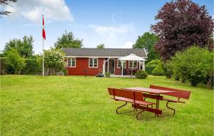 una mesa de picnic frente a una casa roja en Cozy Home In Skibby With Wifi, en Skibby