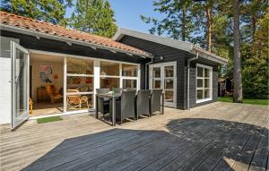 una casa negra con terraza y mesa en Awesome Home In Vggerlse With Kitchen, en Bøtø By