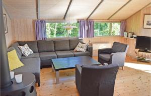 a living room with a couch and a table at Beautiful Home In Grsted With 3 Bedrooms, Sauna And Wifi in Udsholt Sand