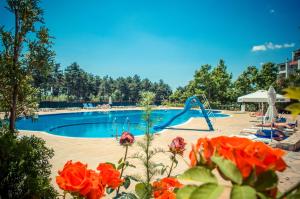 una piscina con tobogán y flores en Green Fort Noks Apartments en Sunny Beach