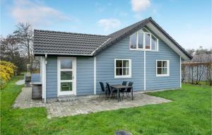Bjerregårdにある3 Bedroom Awesome Home In Hvide Sandeのテーブルと椅子が備わる小さな青い家