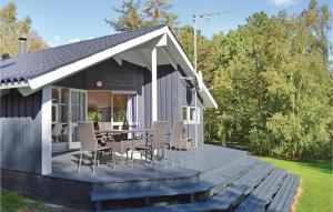 Casa con terraza de madera con mesa y sillas en Beautiful Home In Grsted With 3 Bedrooms, Sauna And Wifi, en Udsholt Sand