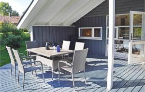 a patio with a table and chairs on a deck at Beautiful Home In Grsted With 3 Bedrooms, Sauna And Wifi in Udsholt Sand