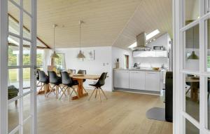 4 Bedroom Amazing Home In Otterup في Otterup: مطبخ وغرفة طعام مع طاولة وكراسي