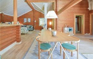a dining room with a table and chairs in a cabin at Awesome Home In Lundby With Private Swimming Pool, Can Be Inside Or Outside in Lundby