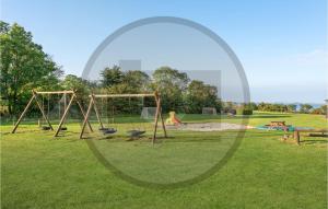 un patio de juegos vacío con columpios en un parque en Awesome Home In Faaborg With House Sea View, en Faaborg