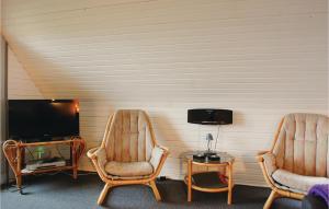 ÅrøにあるPet Friendly Home In Haderslev With Wifiのテレビ付きの客室で、椅子2脚とテーブル1台が備わります。