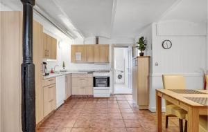 a kitchen with white appliances and a table with chairs at Stunning Apartment In Esbjerg V in Esbjerg
