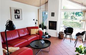 Vester SømarkenにあるGorgeous Home In Aakirkeby With Kitchenのリビングルーム(赤いソファ、テーブル付)