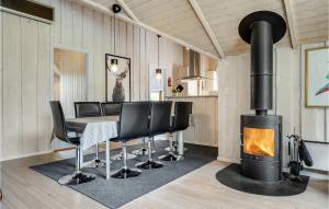 FjellerupにあるBeautiful Home In Glesborg With 3 Bedrooms, Sauna And Wifiのダイニングルーム(暖炉、テーブル、椅子付)
