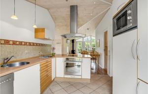 a kitchen with a sink and a stove at Holiday Home Flyndervej Tarm I in Hemmet