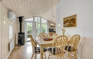 a kitchen and dining room with a wooden table and chairs at Holiday Home Flyndervej Tarm I in Hemmet