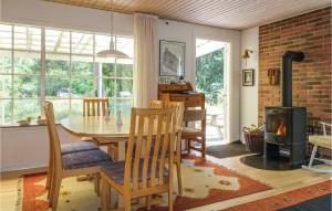 a dining room with a table and a fireplace at Beautiful Home In Nex With 4 Bedrooms in Neksø