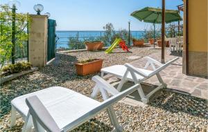 a patio with two chairs and an umbrella and a playground at La Casa Gialla in Framura