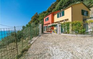 a house on the side of a hill with a fence at La Casa Gialla in Framura