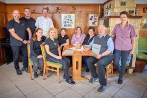 a group of people posing for a picture at a table at Gasthof Hillig in Bad Gottleuba