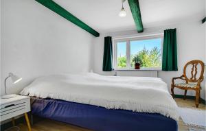 Un dormitorio con una cama grande y una ventana en Cozy Home In Stubbekbing With Kitchen, en Stubbekøbing